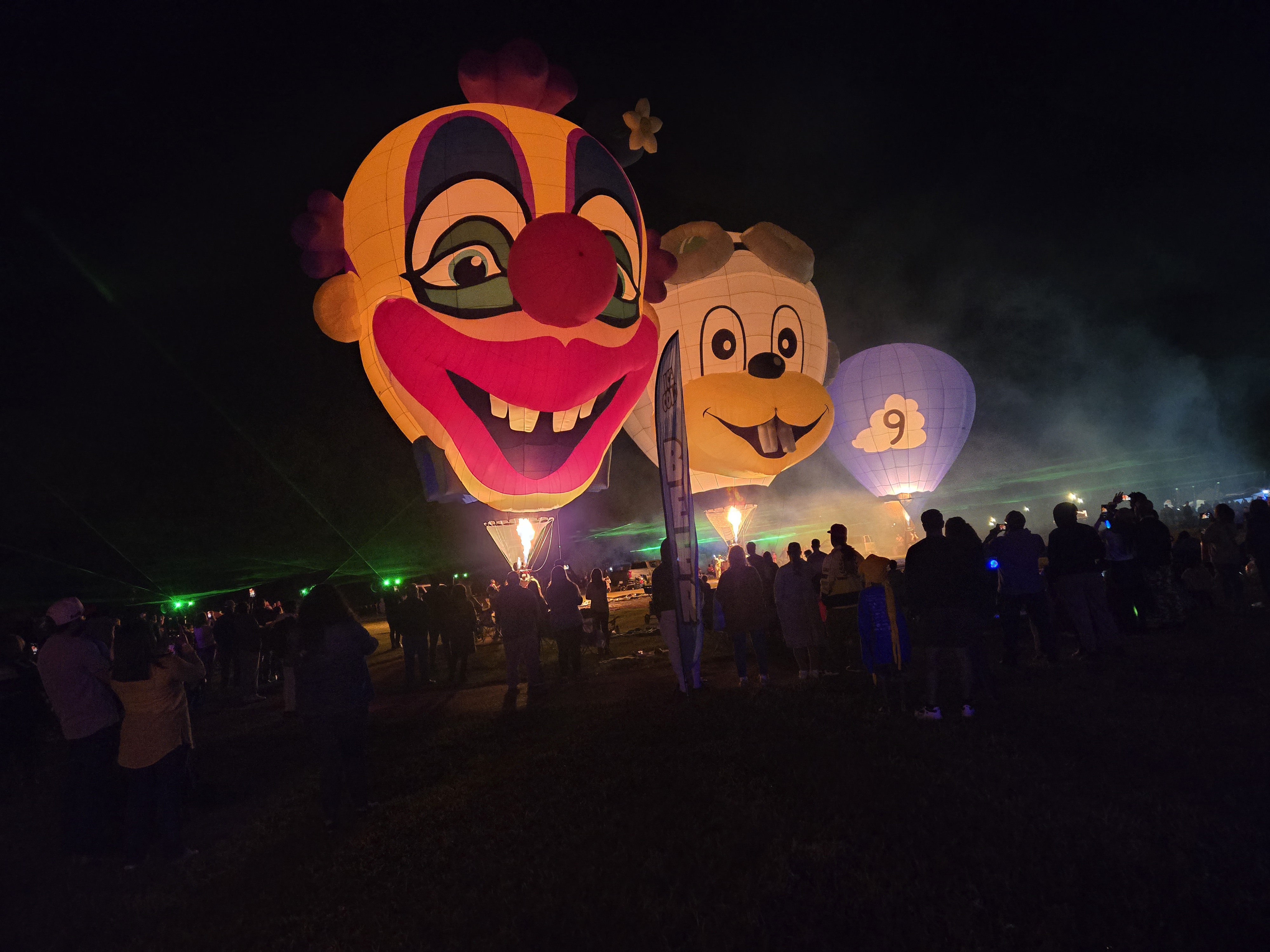 Massive glowing balloon characters towering over the crowd at a balloon glow event