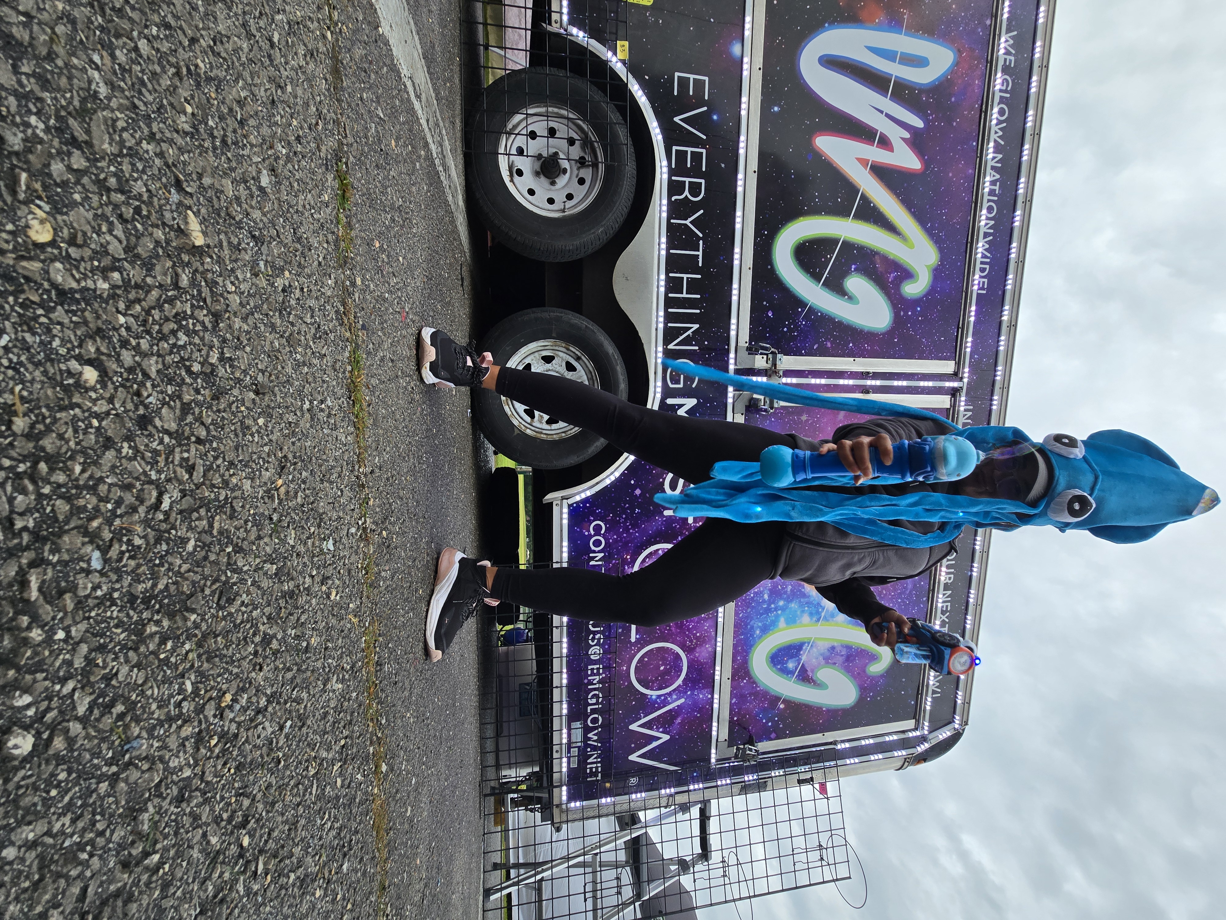 Showing off a balloon sword creation in front of the lit-up EMG trailer