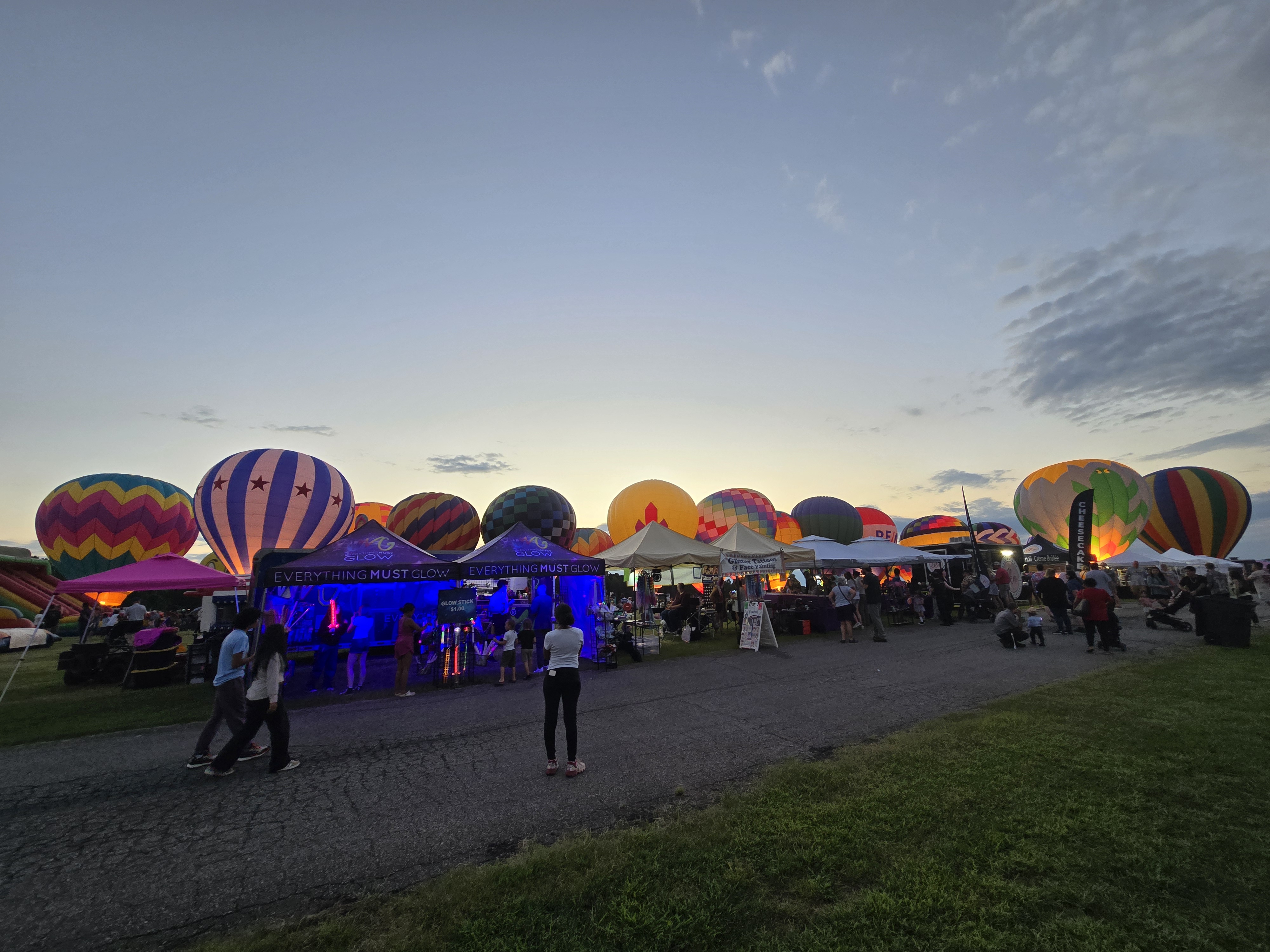Our booth glowing blue at dusk surrounded by a stunning lineup of hot air balloons