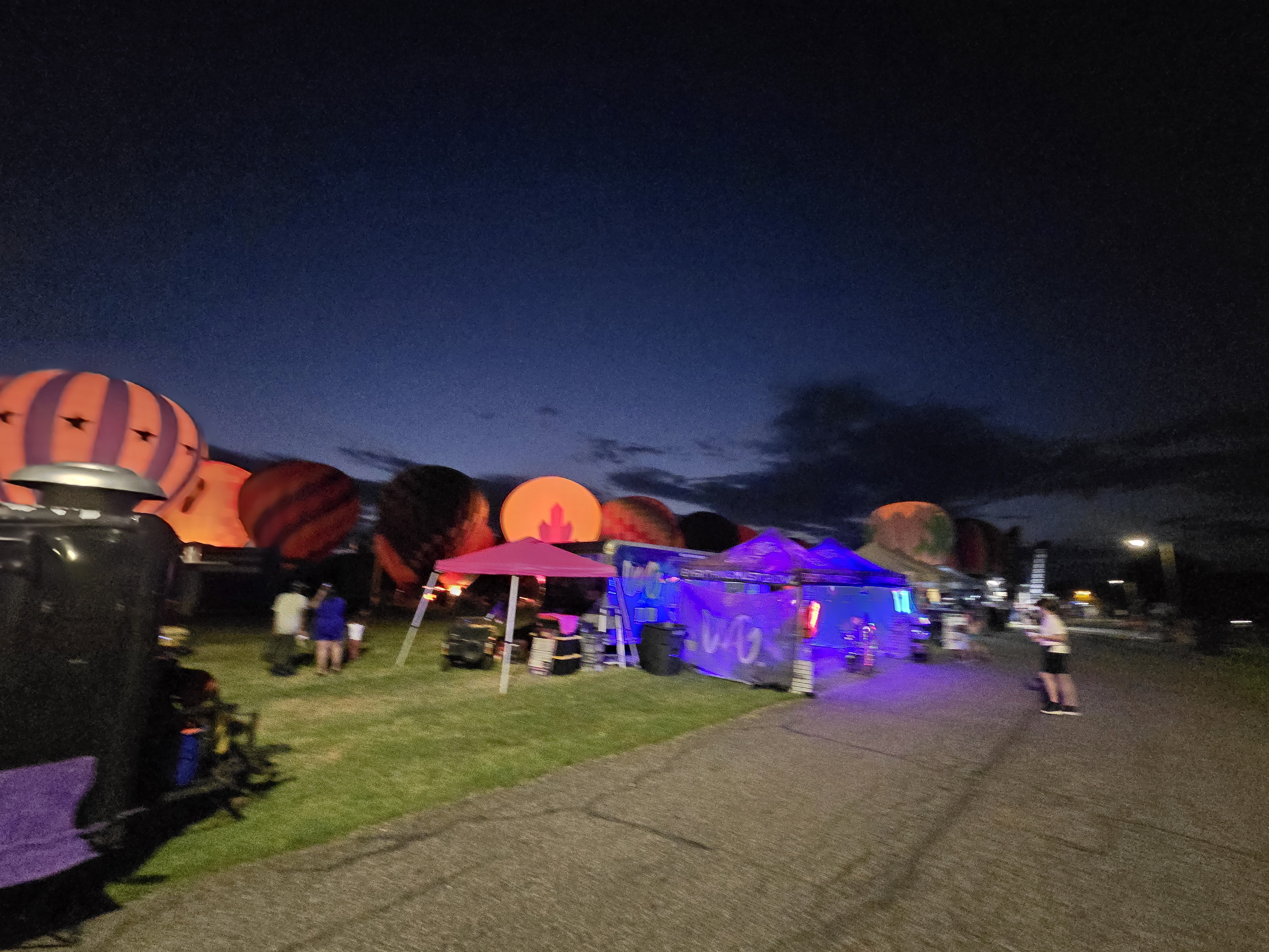 Our booth lit up in blue as balloons glow behind us at sunset