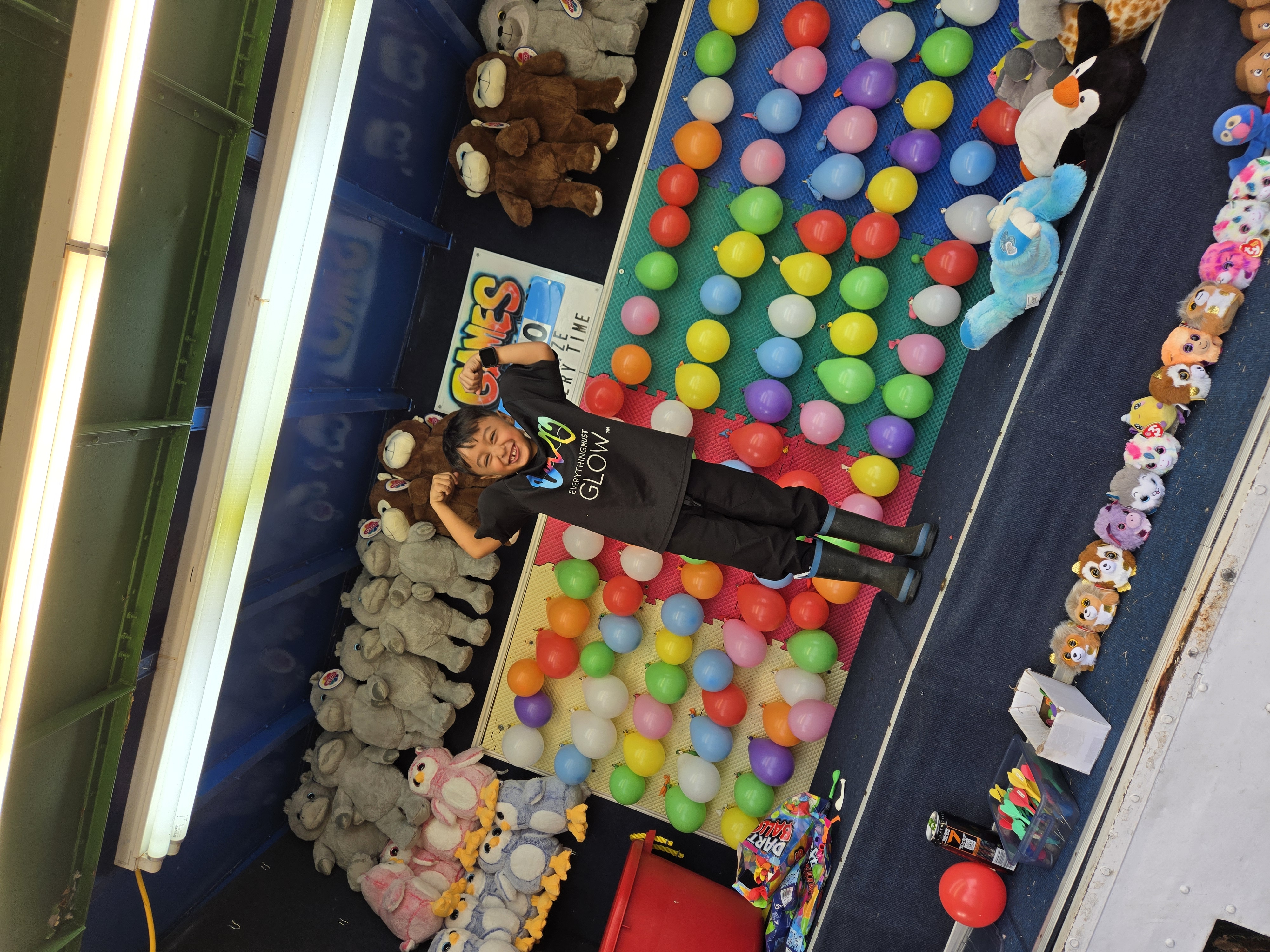 One of our little ones posing in front of the balloon dart board wearing EMG gear
