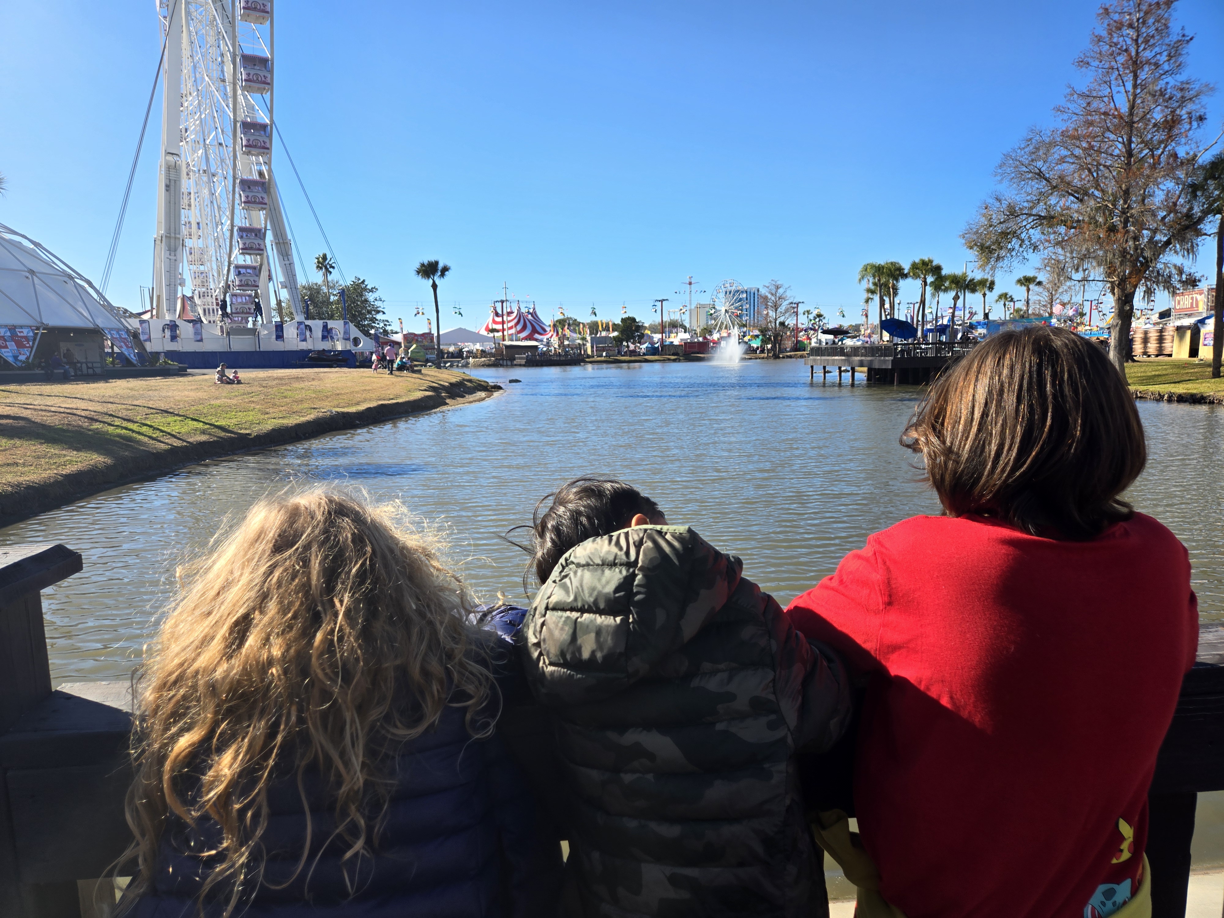 The kids checking out a ferris wheel and waterfront scene while on the road