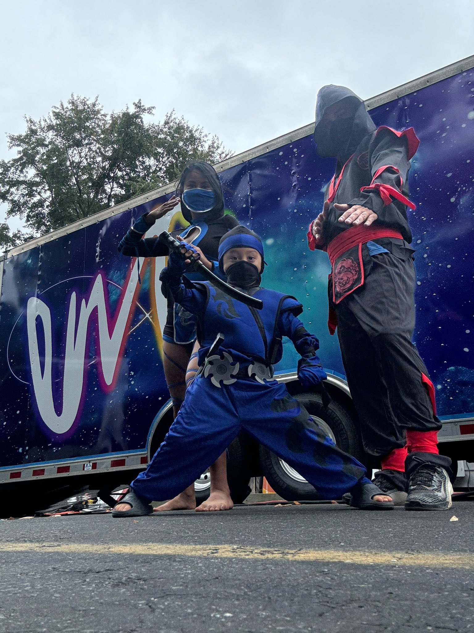 The kids striking ninja poses in front of the EMG trailer — always an adventure